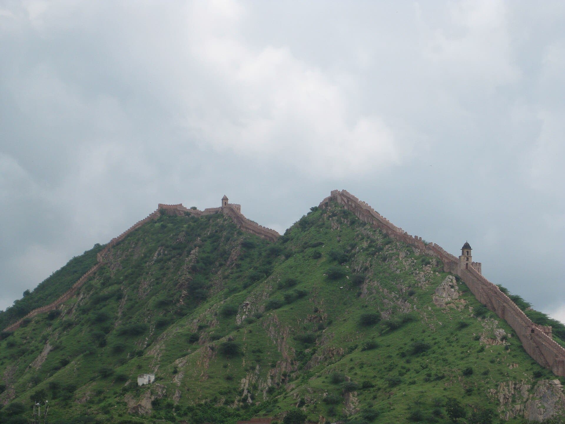 Photo: vineet kaul · CC BY-SA 3.0, via Wikimedia Commons A fort wall climbing the green Amer hills near Jaipur